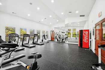 the gym with cardio machines and other exercise equipment at the belgard apartments